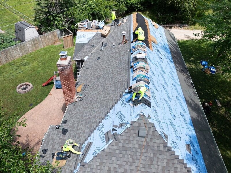 Workers on roof fixing storm damage